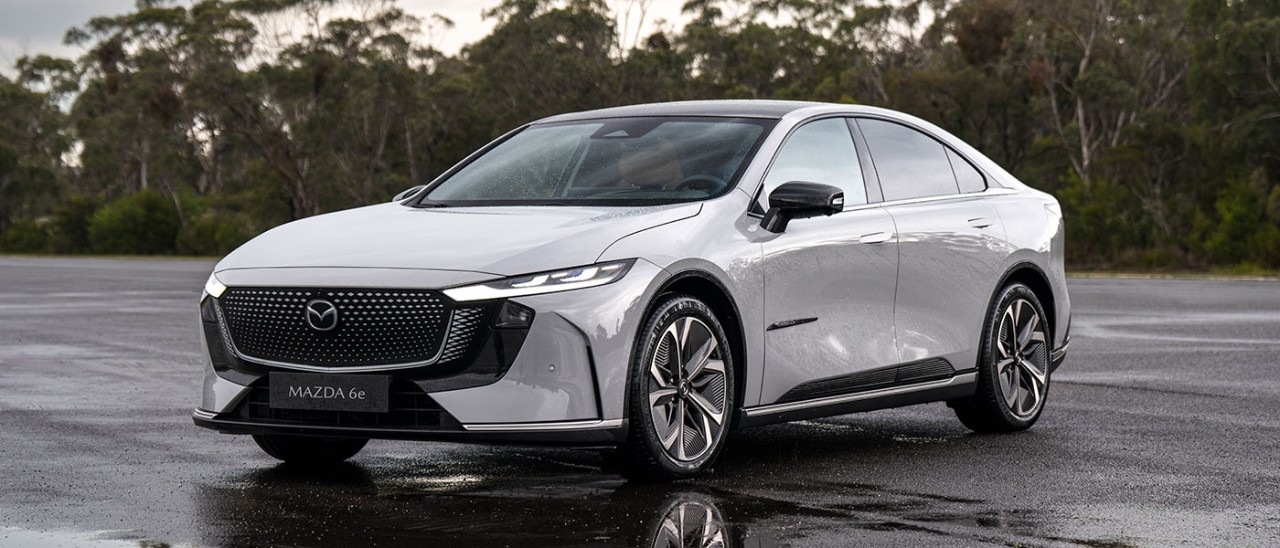 Light grey LHD Euro-spec Mazda 6e sedan on wet bitumen forecourt at Lang Lang proving ground in Victoria.