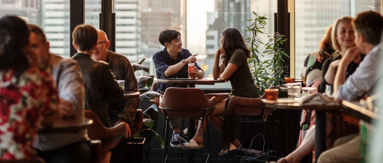 group of people drinking in a rooftop bar