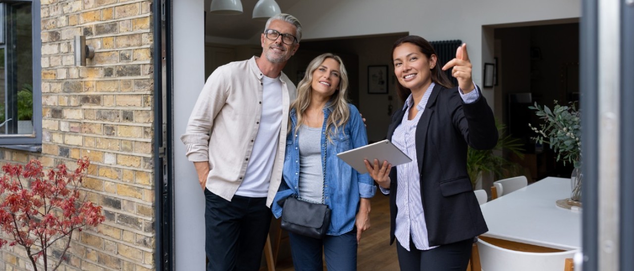 middle-aged couple talking with rental agent at their home