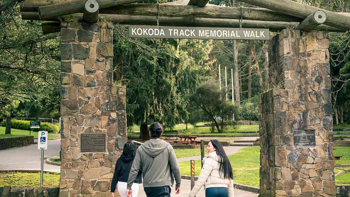 Three people at Kokoda Track Memorial Walk entrance