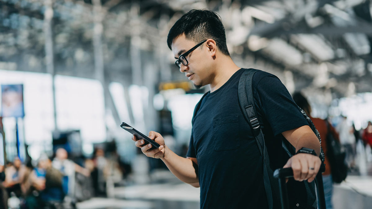 man using smartphone in airport