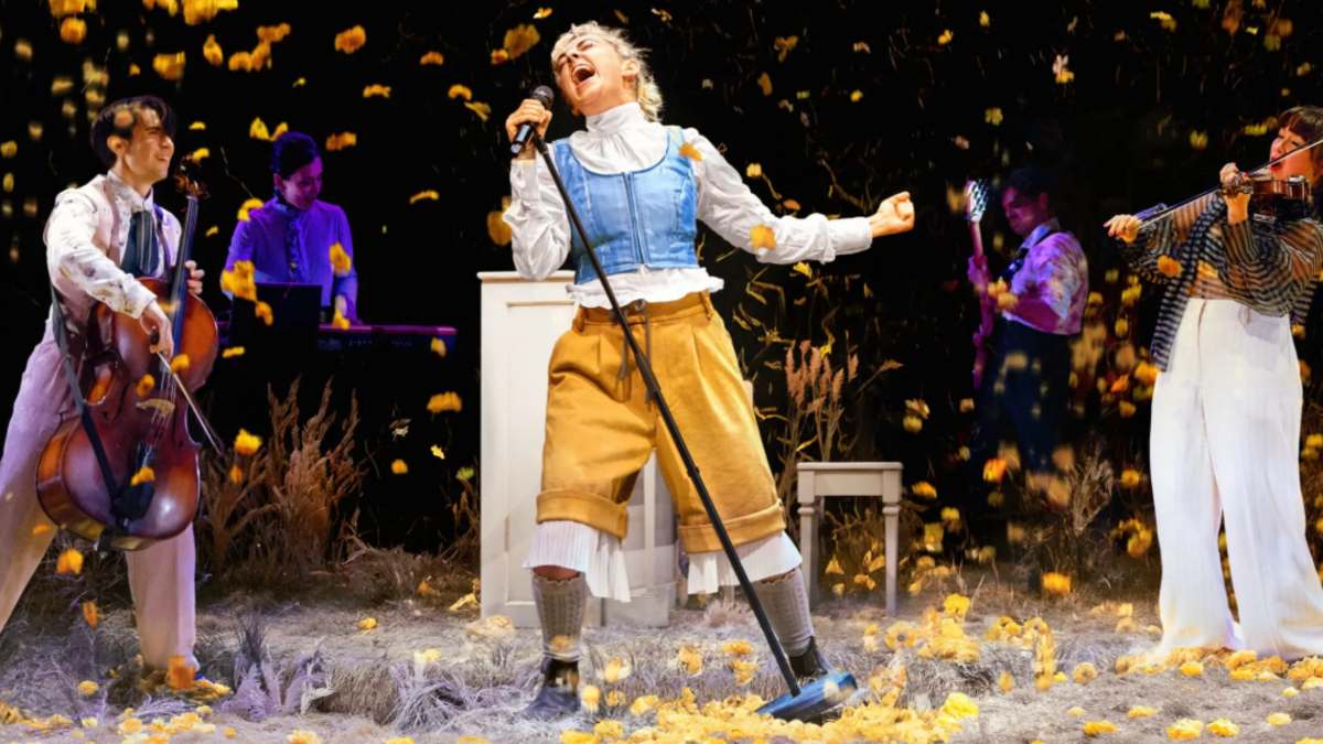 female singer on stage with musicians around her