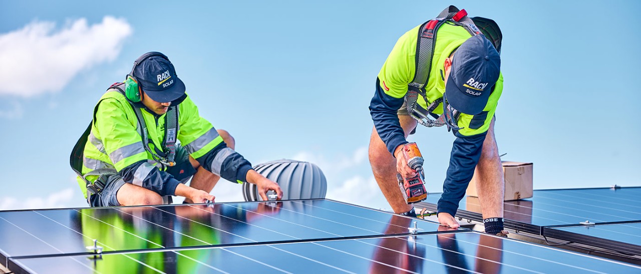 Two tradespeople installing solar panels