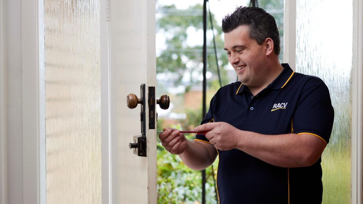 A locksmith working on a front door