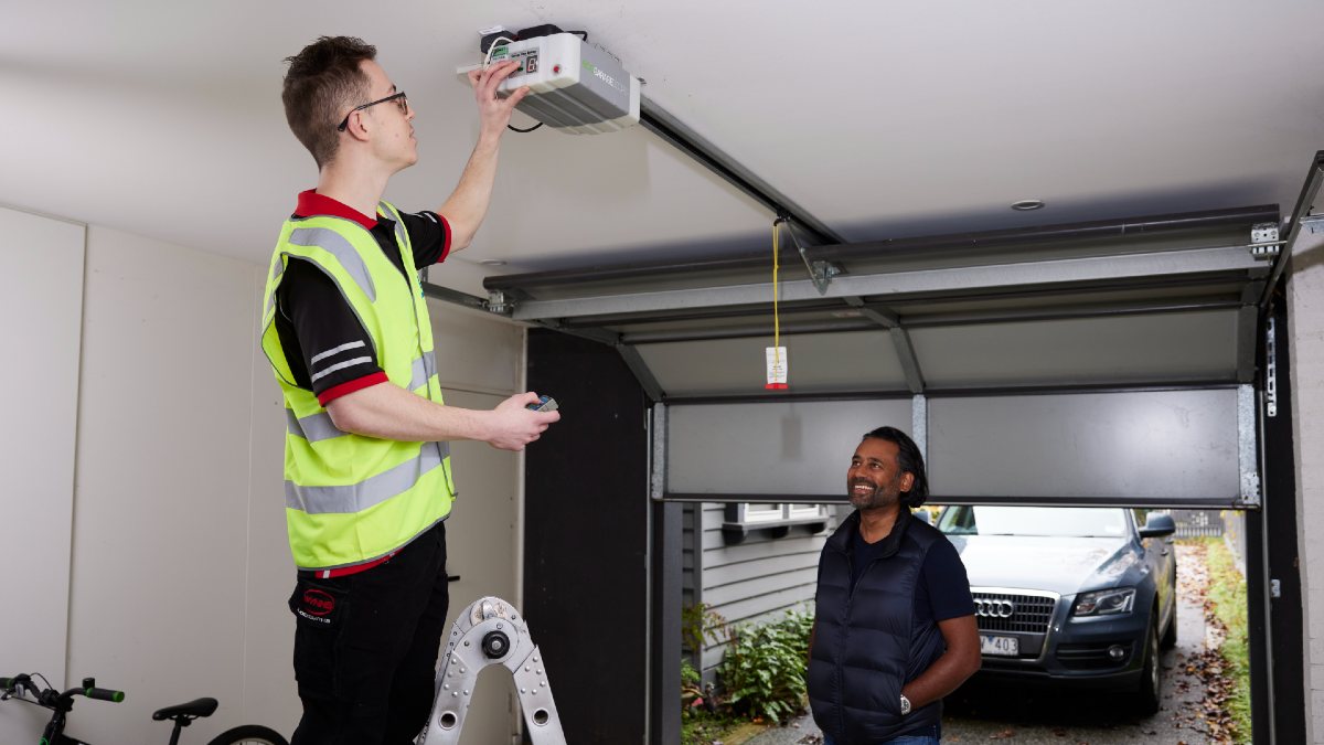 RACV electrician fixing garage door while homeowner watches