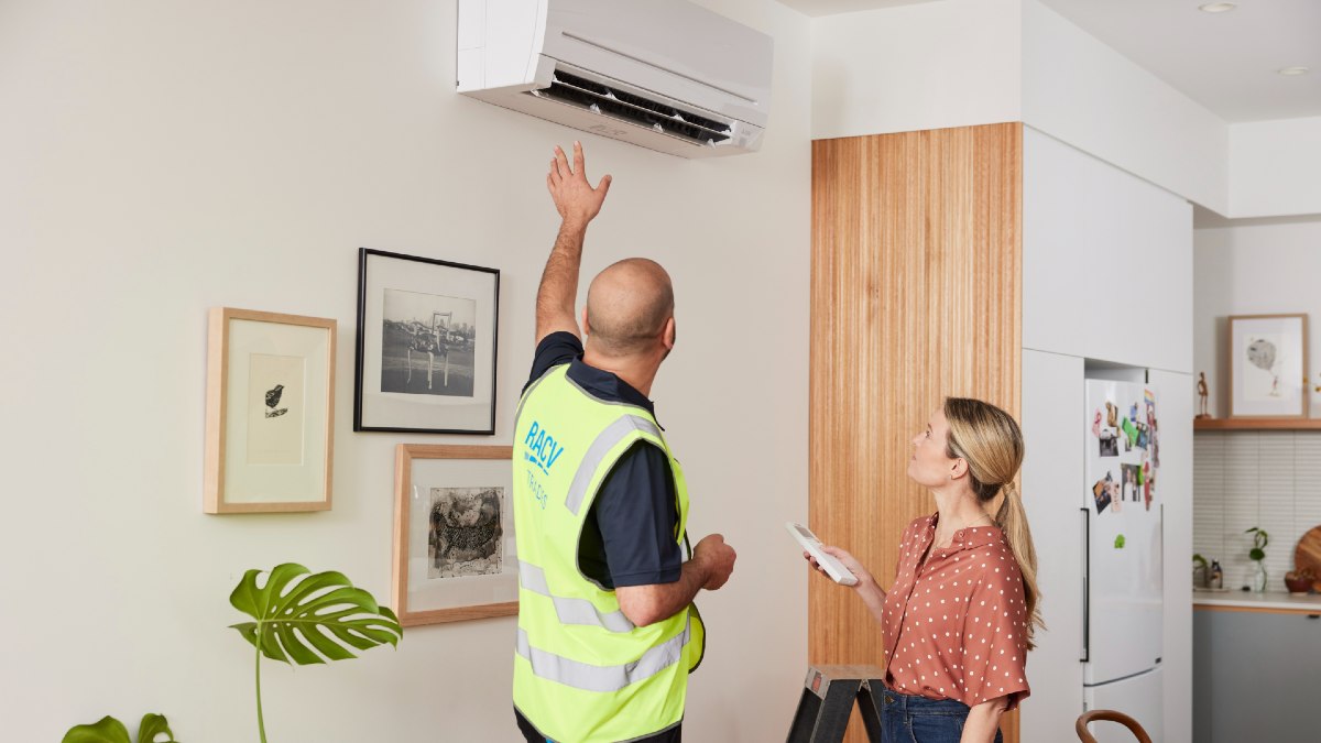 RACV electrician talking to homeowner about her air conditioning unit