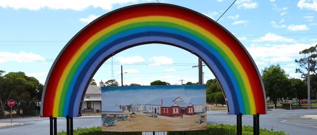 Rainbow sign at entrance to town