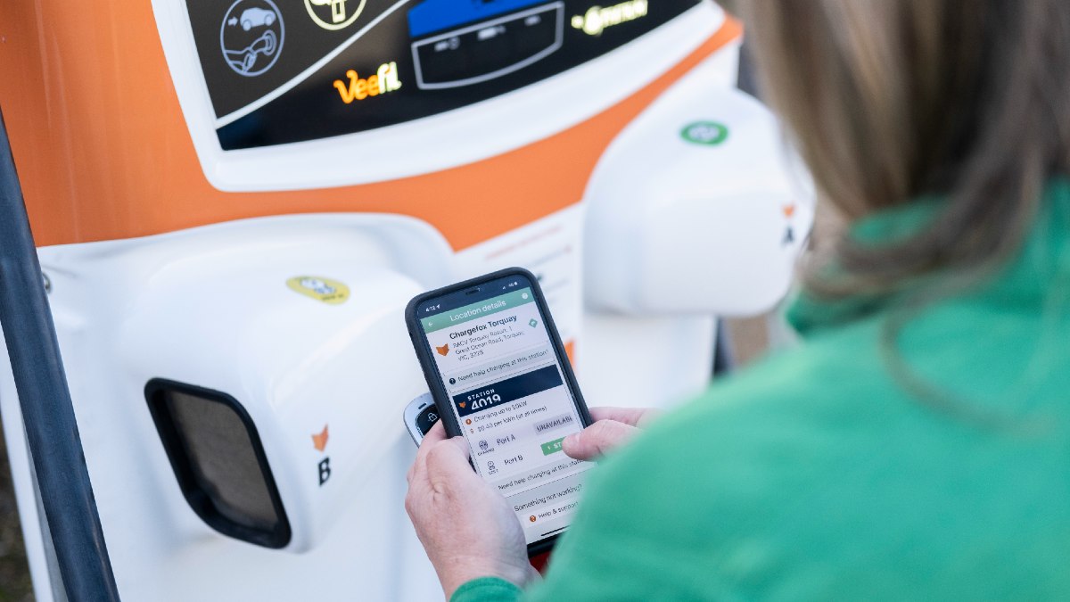 woman looking at EV charging stations on her phone