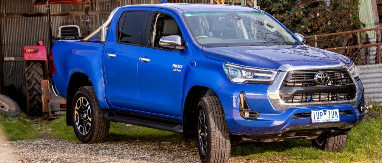 A 2022 Toyota Hilux abandoned by a farm building