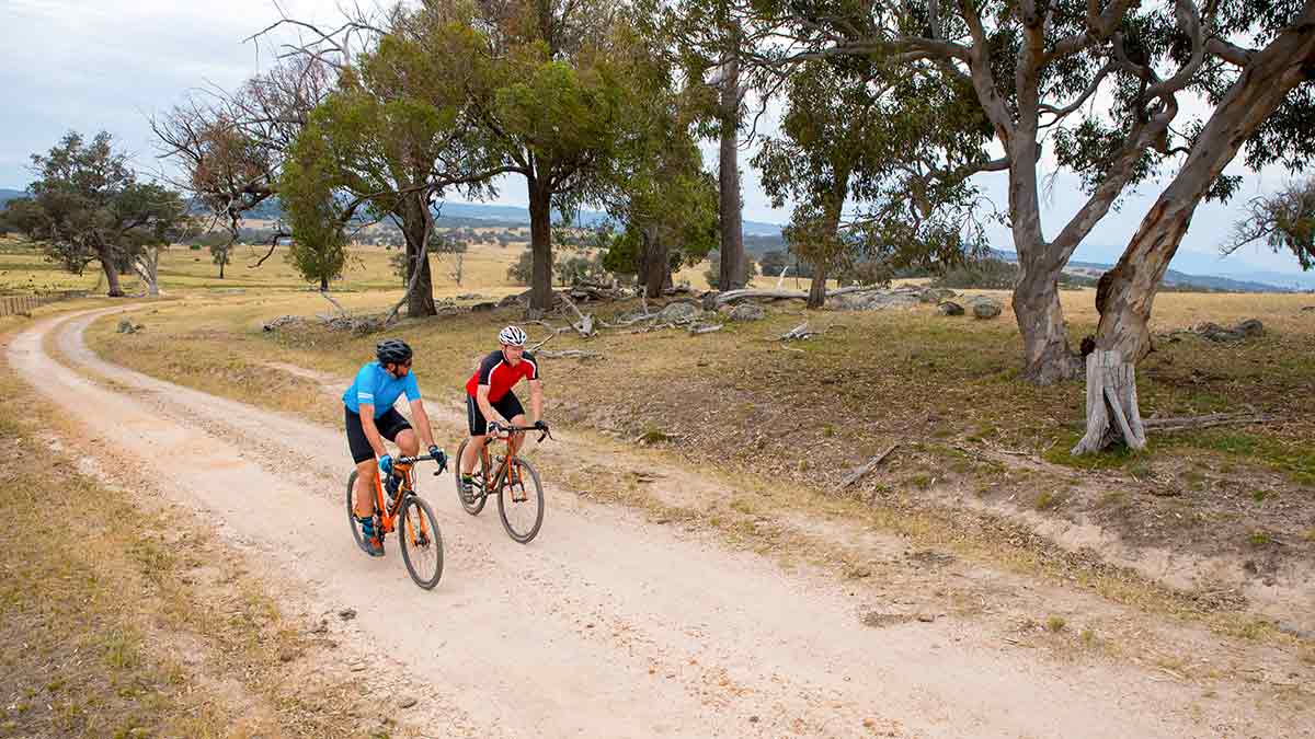 Two men cycling along a dirt track in country Victoria
