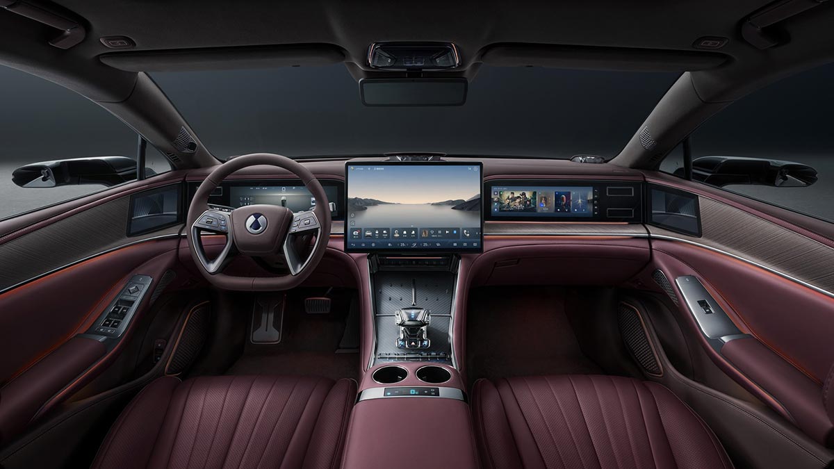 Luxurious cockpit of left-hand-drive Denza Z9 GT with burgundy leather trim and three screens across dash.
