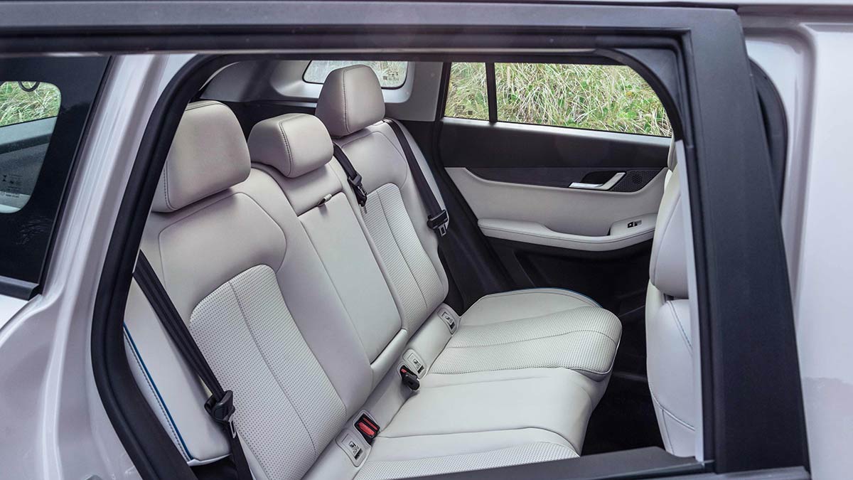 View of white-trimmed rear seat area of Jaecoo J5 SUV as seen through right rear window.
