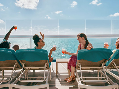 Four passengers on a Carnival cruise enjoying a drink 