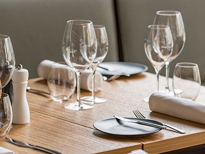 A table at RACV Hobart Hotel's Charcoal restaurant, set with wine glasses, plates, napkins and cutlery.