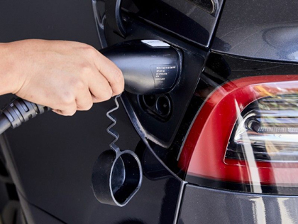 A person charging an electric vehicle.