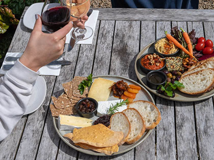 Tasting plates at Green Olive Farmers Lunch, featuring breads and cheese with red wine.