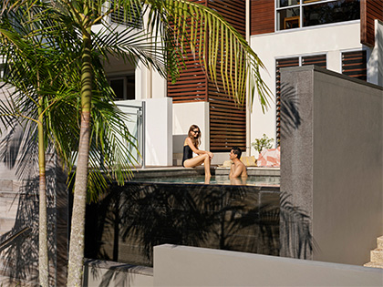 Couple relaxing in the pool on a sunny day at Noosa Resorts, Queensland. 