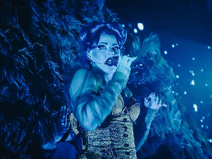 Actor on dark stage performing in Dracula's cabaret.