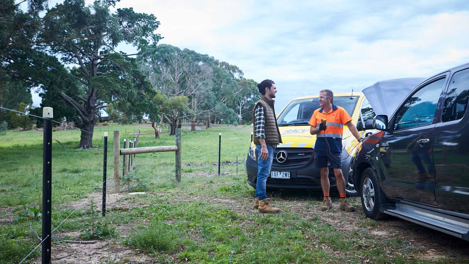 RACV roadside assistance technician in a rural area testing a customers battery.