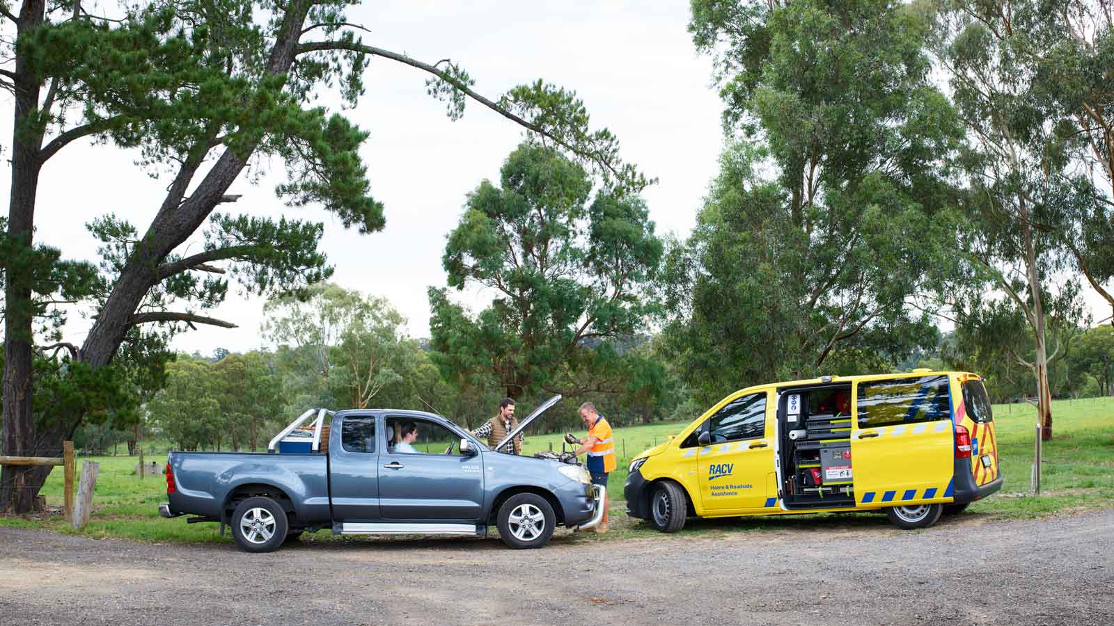 RACV patrolman in a rural area testing a customers battery on the roadside.