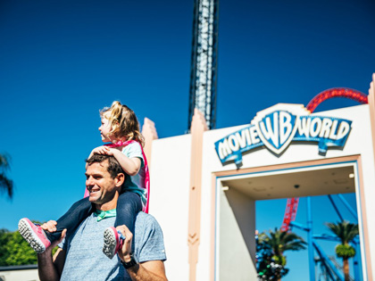 Daughter on her fathers shoulders at Movie World