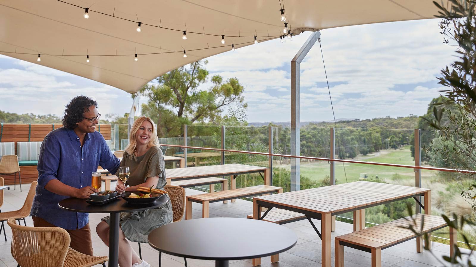 Couple having drinks in beer garden at Three Founders restaurant at RACV Goldfields resort.