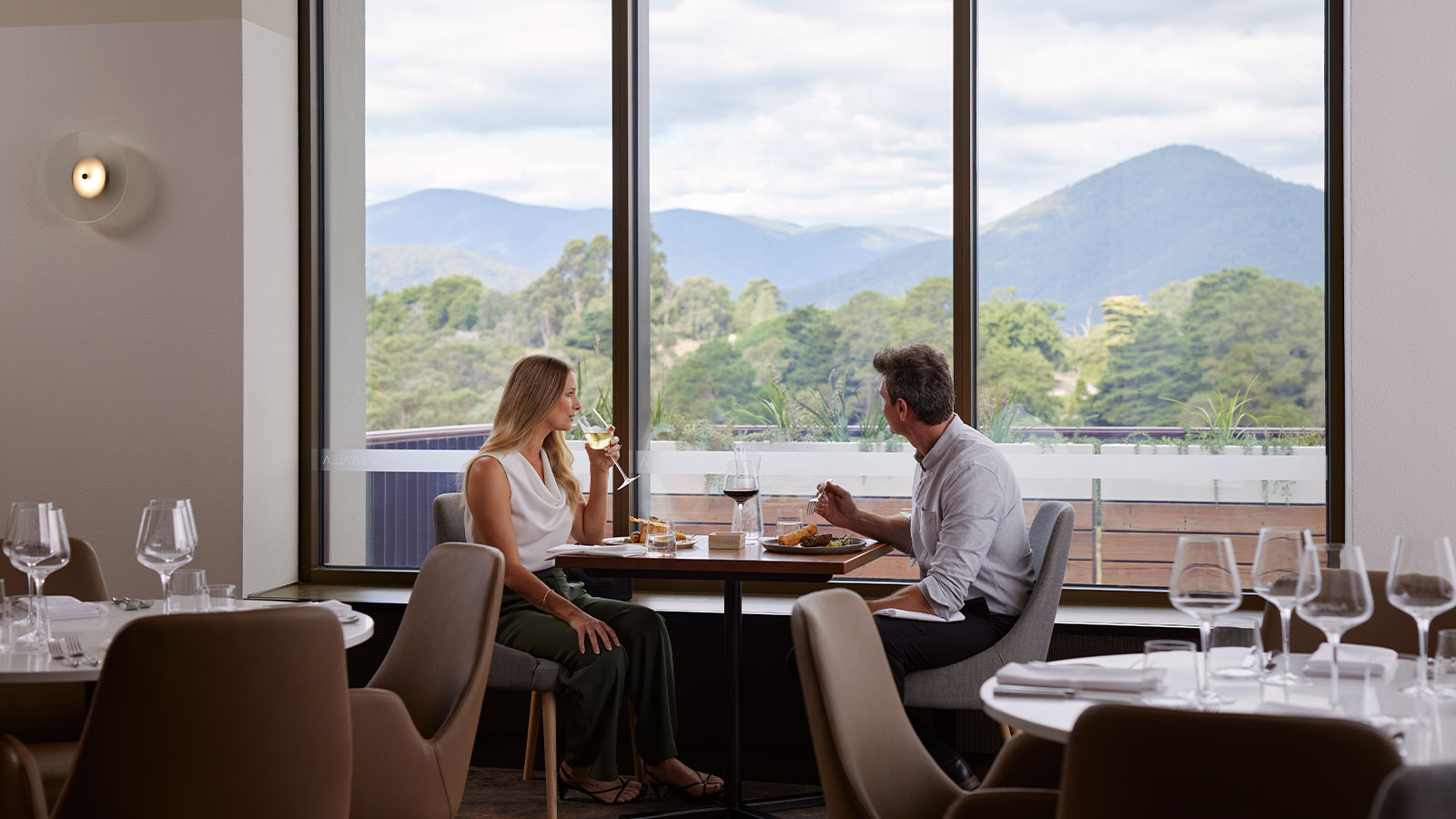 A couple enjoying the view from the dining area of Banyalla restaurant, Healesville Country Club.