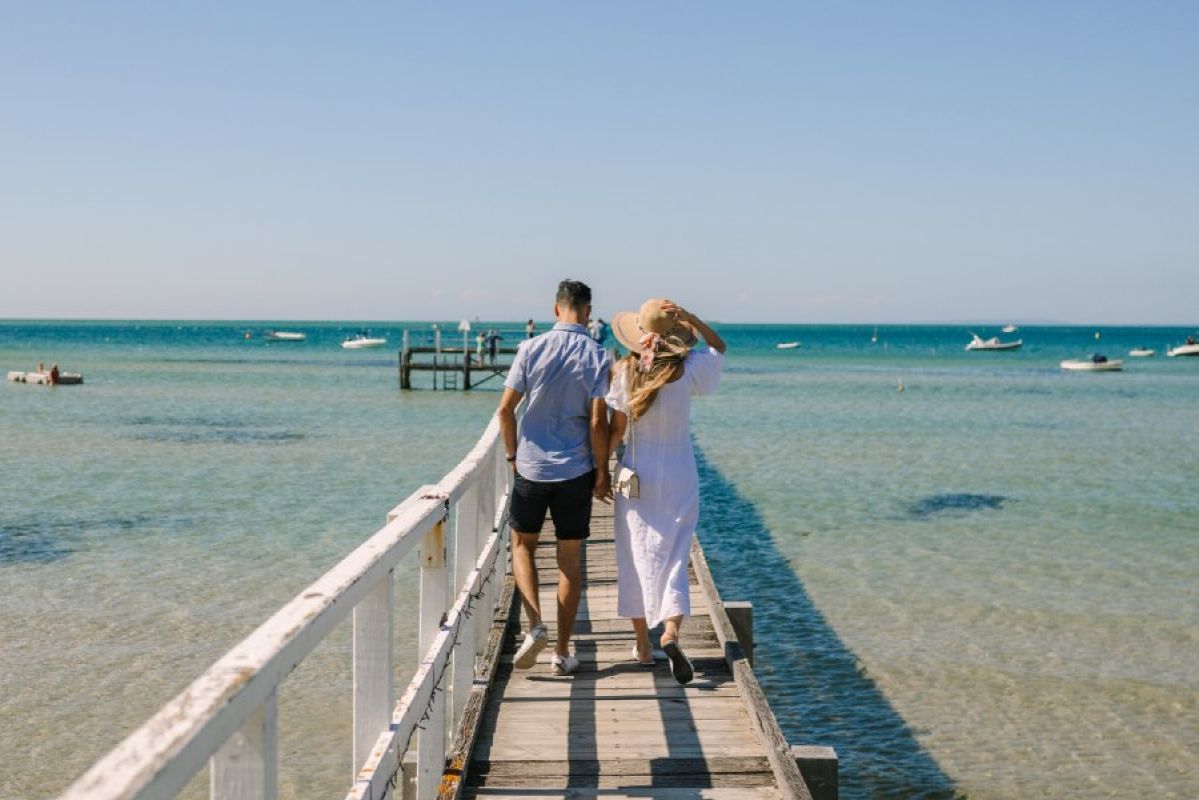 A couple strolling along Sorrento Pier on a sunny afternoon