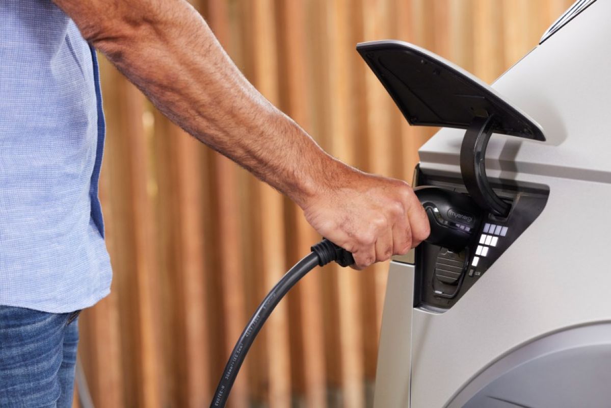 man charging a white EV