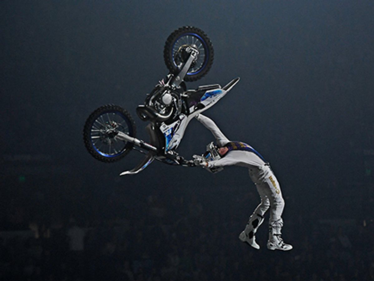 A person doing a backflip in the air on a motorbike