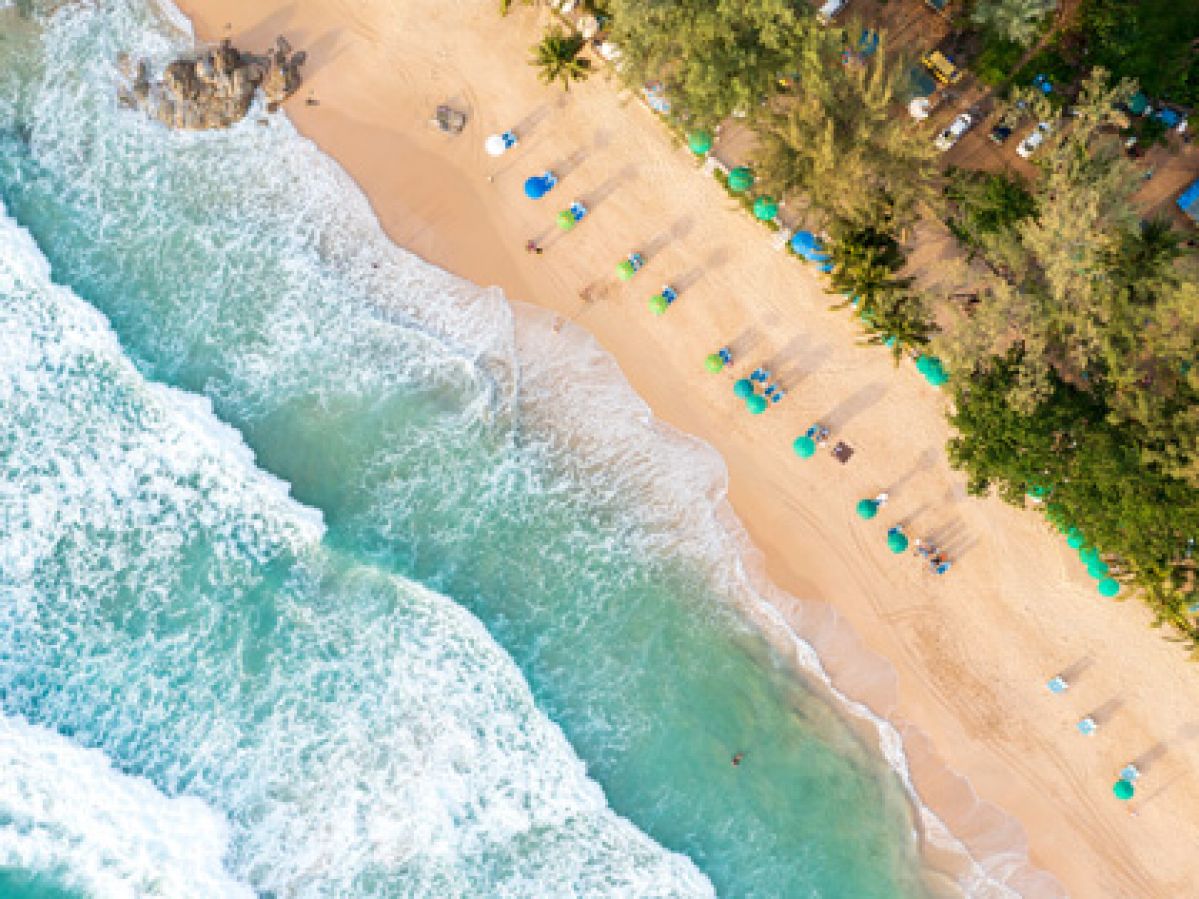 Aerial drone top view crowd of happy people relaxing at tropical beach in Phuket, Thailand