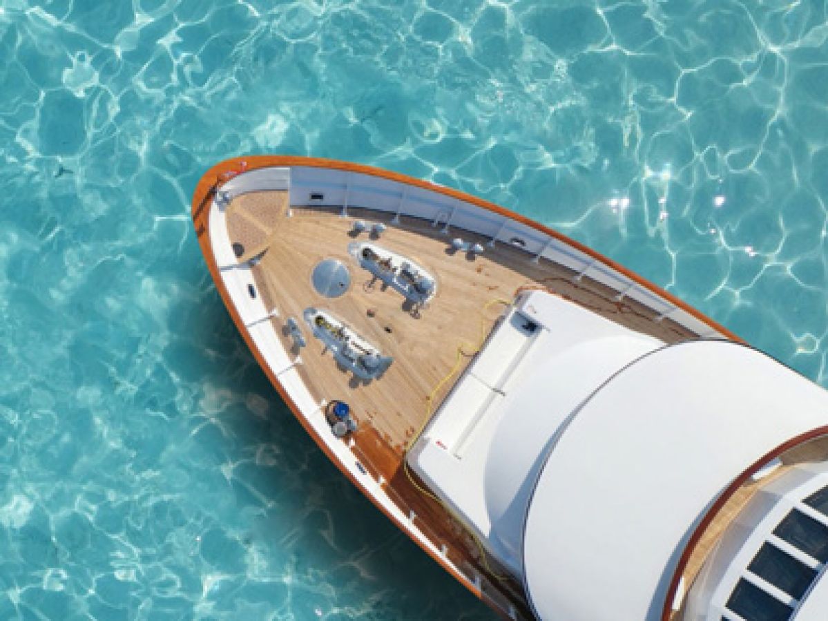 Top of boat on clear blue water.