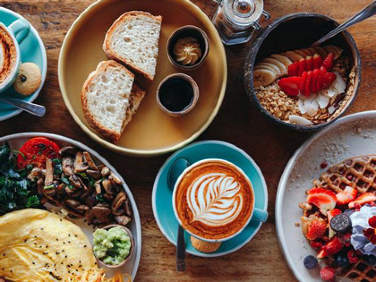 An array of dishes of food and drink spread on a table.