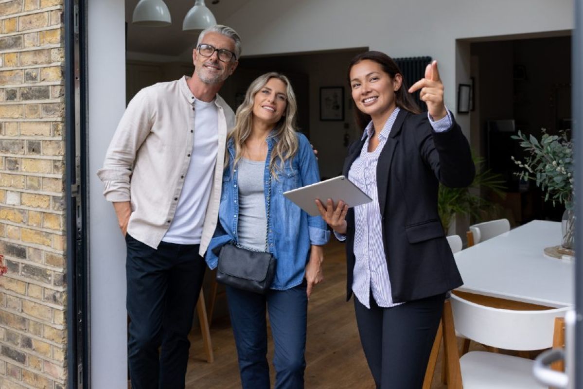middle-aged couple talking with rental agent at their home