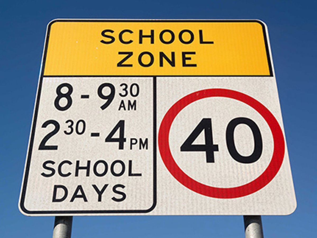 School zone sign detailing the speed limit during specific times on school days.