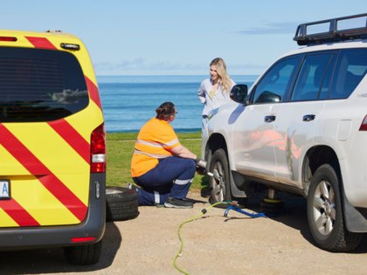 ERA mechanic fixing a flat tyre on a white SUV.