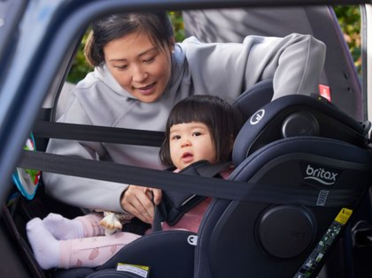 Mum straps baby into car seat
