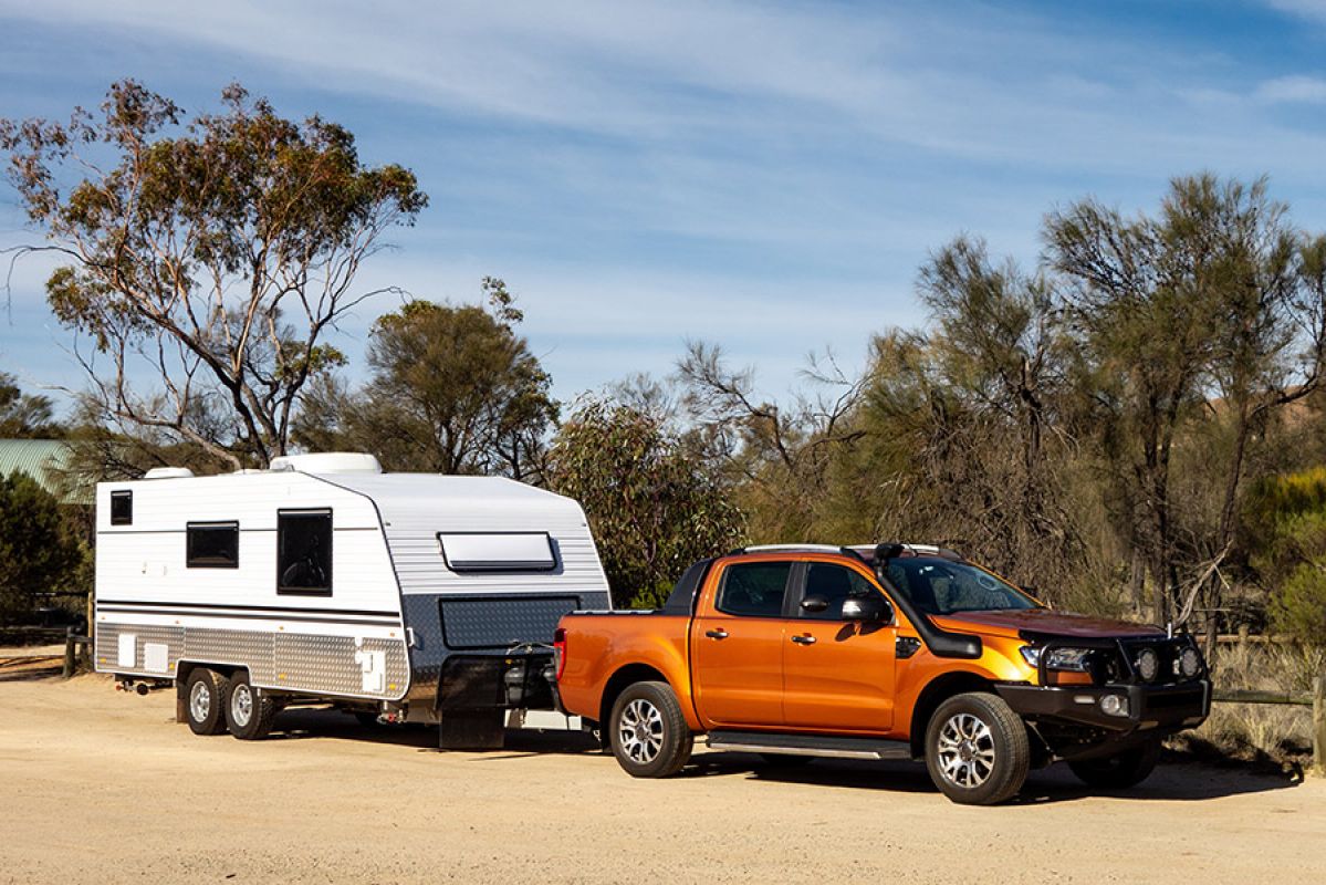 man and woman standing in front of a caravan