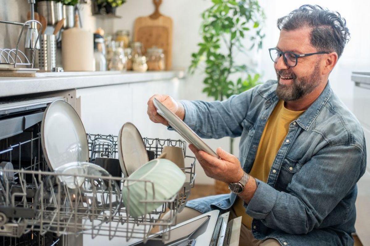 Man unloading a dishwasher