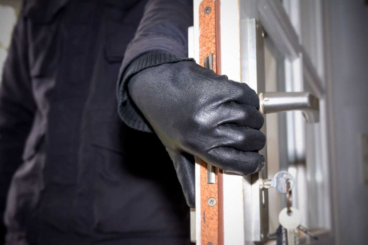 burglar wearing leather gloves opening an unlocked house door