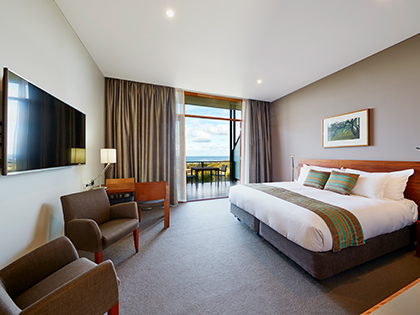 Premium ocean view room at RACV Inverloch Resort, featuring a king bed, couches and television.