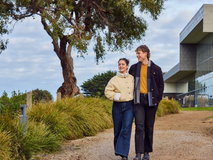 A young couple strolling outside on the grounds of RACV Inverloch resort. 