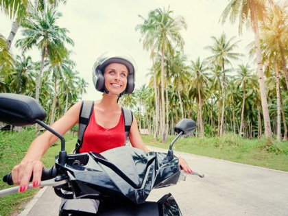 A young woman riding a motorcycle in Bali.