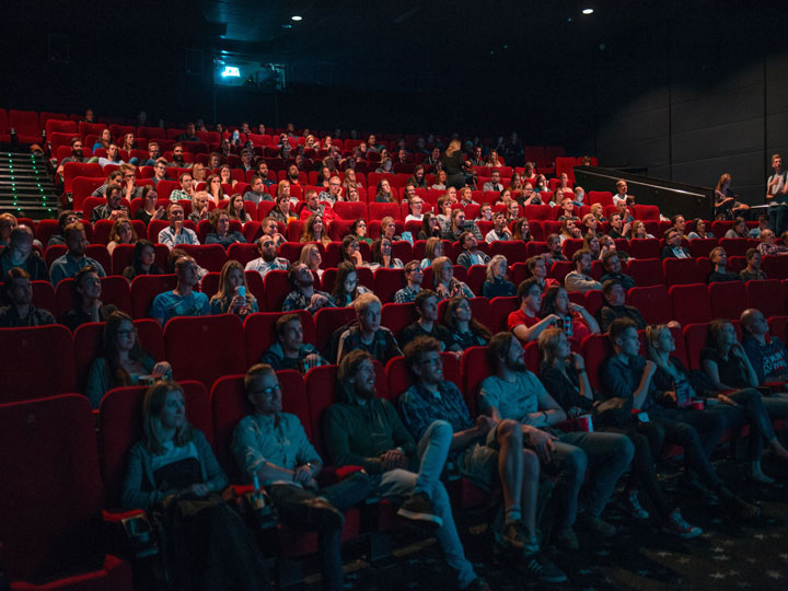 Large group of people watching a film at the cinema.