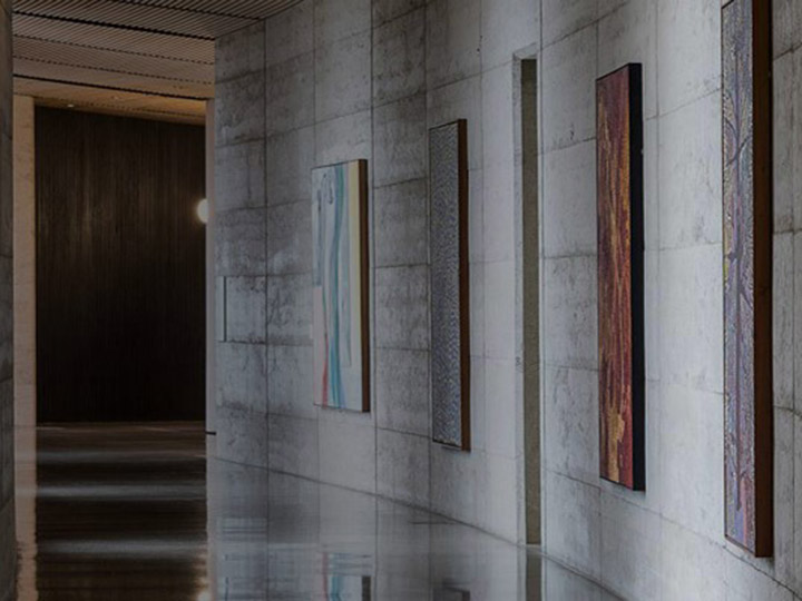 Image of an art-lined corridor with concrete walls at one of the RACV resorts.