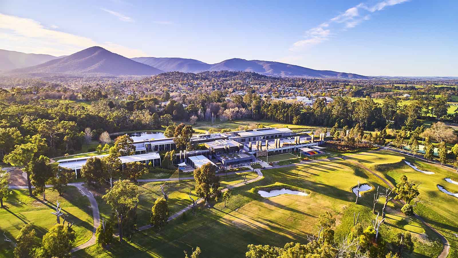 Aerial view of RACV Country Club and surrounding mountains.