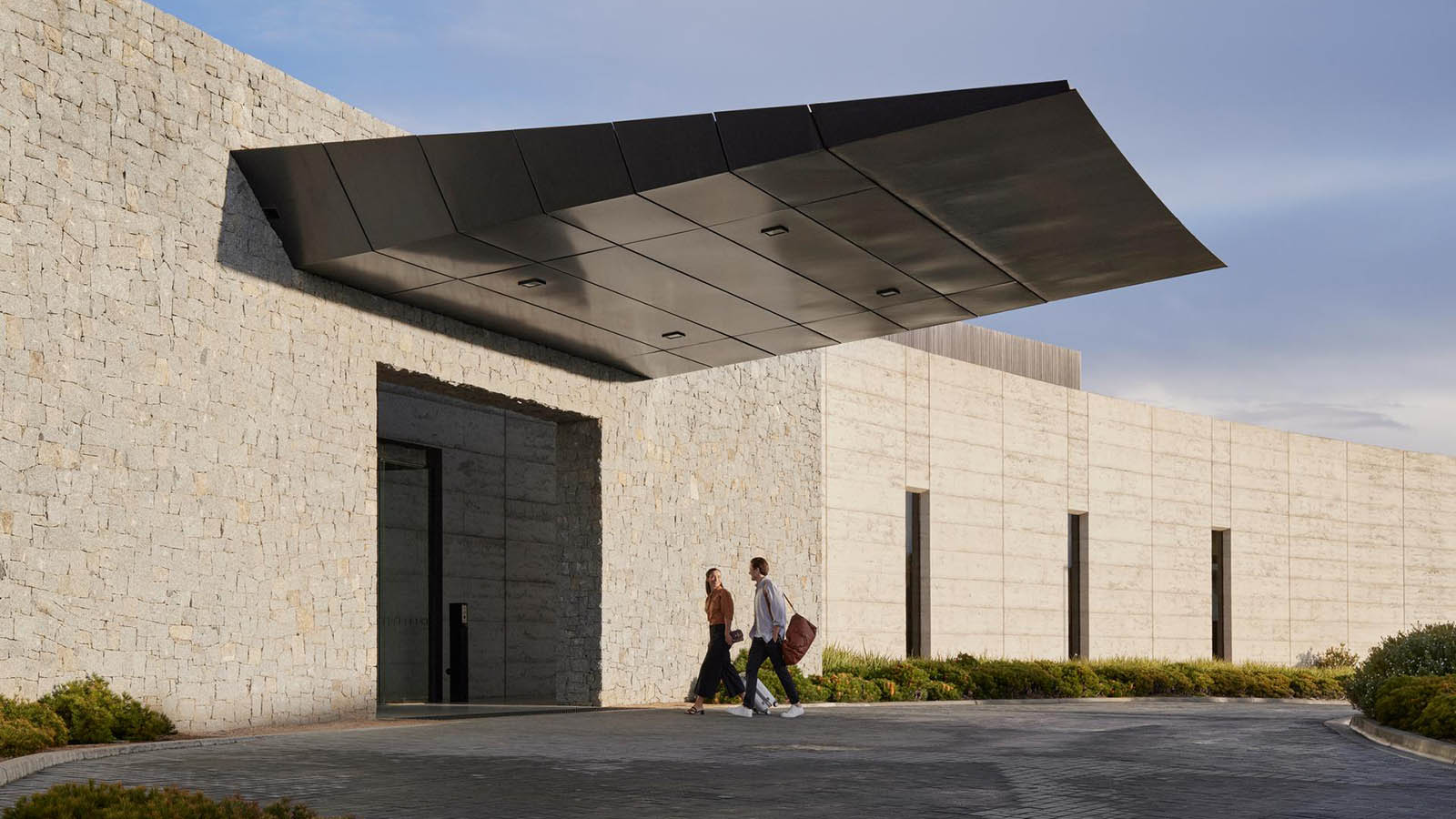 Couple walking up to RACV Torquay Resort's front entrance.