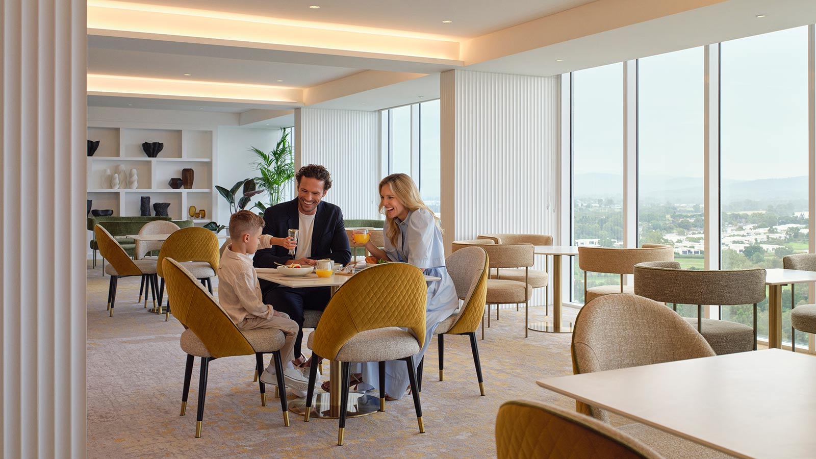Parents and child sitting and eating together in the Executive Lounge at RACV Royal Pines Resort.