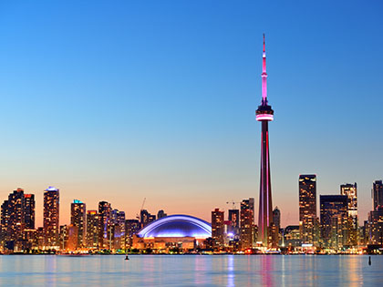 Toronto sunset over lake panorama with urban skyline.