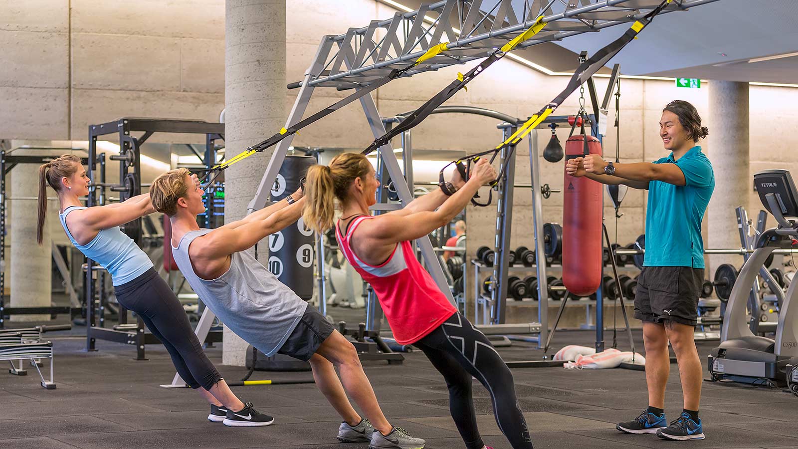 Person teaching suspension training class to three people at RACV Torquay Resort's One Lifestyle fitness centre.